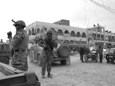 
Iraqi soldiers control an intersection Thursday in the Shiite enclave of Sadr City in Baghdad, Iraq, where  U.S. and Iraqi forces conducted searches for weapons. 
 (Associated Press / The Spokesman-Review)