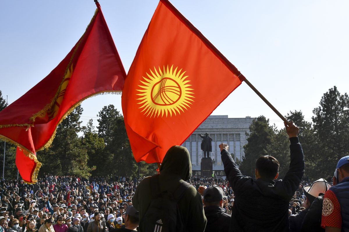 Protesters react waving Kyrgyz national flags as they wait for Kyrgyz Prime Minister Sadyr Zhaparov speech in front of the government building in Bishkek, Kyrgyzstan, Wednesday, Oct. 14, 2020. Kyrgyzstan