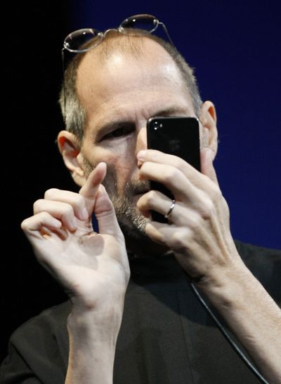  In this June 7  photo, Apple CEO Steve Jobs uses the new iPhone 4 at the Apple Worldwide Developers Conference in San Francisco.  (Associated Press)