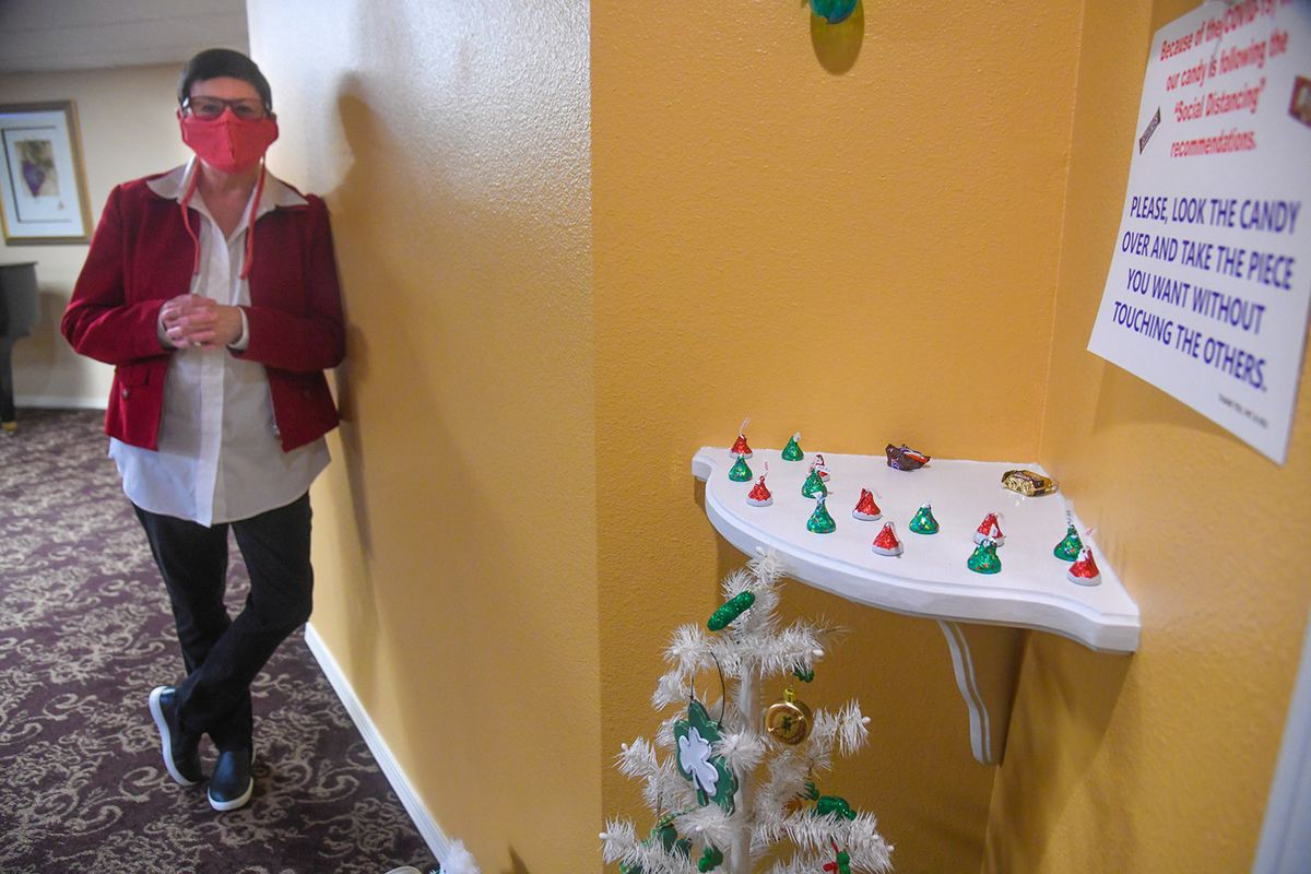 Pat Thompson offers candy treats to passersby outside her door at TouchMark on South Hill in Spokane.  (DAN PELLE/THE SPOKESMAN-REVIEW)