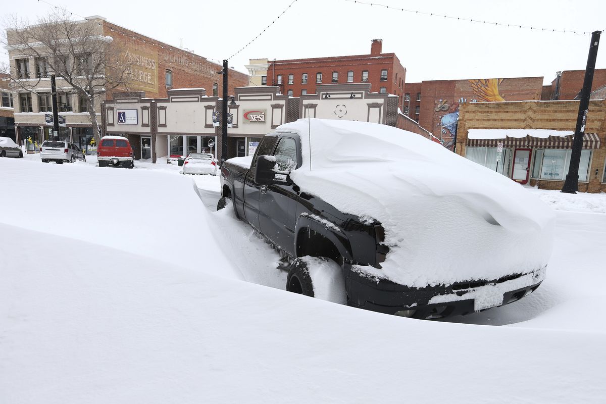 A pickup truck sits covered in snow in downtown Cheyenne, Wyo. on Monday, March 15, 2021. Denver