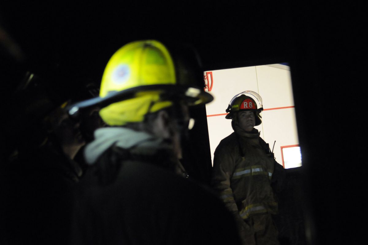 Firefighters get briefed in the second story of the rebuilt fire tower before night drill training exercises last Thursday. (J. Bart Rayniak)