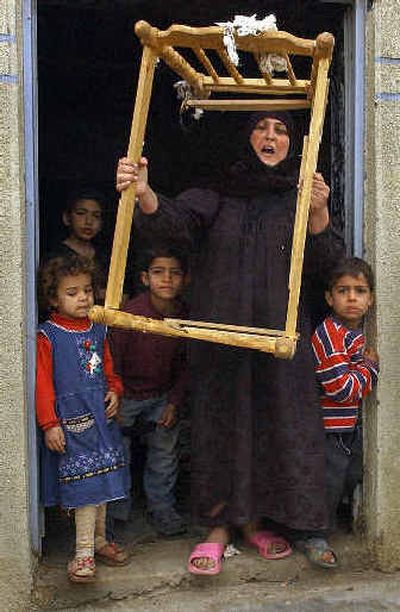 
An angry Iraqi woman shows a child's cot she claims was broken along with other household items during a raid by U.S. forces on her house in Baghdad on Monday. Officials were unable to independently confirm the raid.
 (Associated Press / The Spokesman-Review)