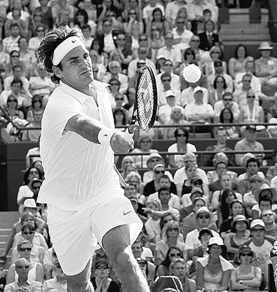 Roger Federer looks to make a forehand return to Ilija Bozoljac during their second-round match at Wimbledon. (Associated Press)