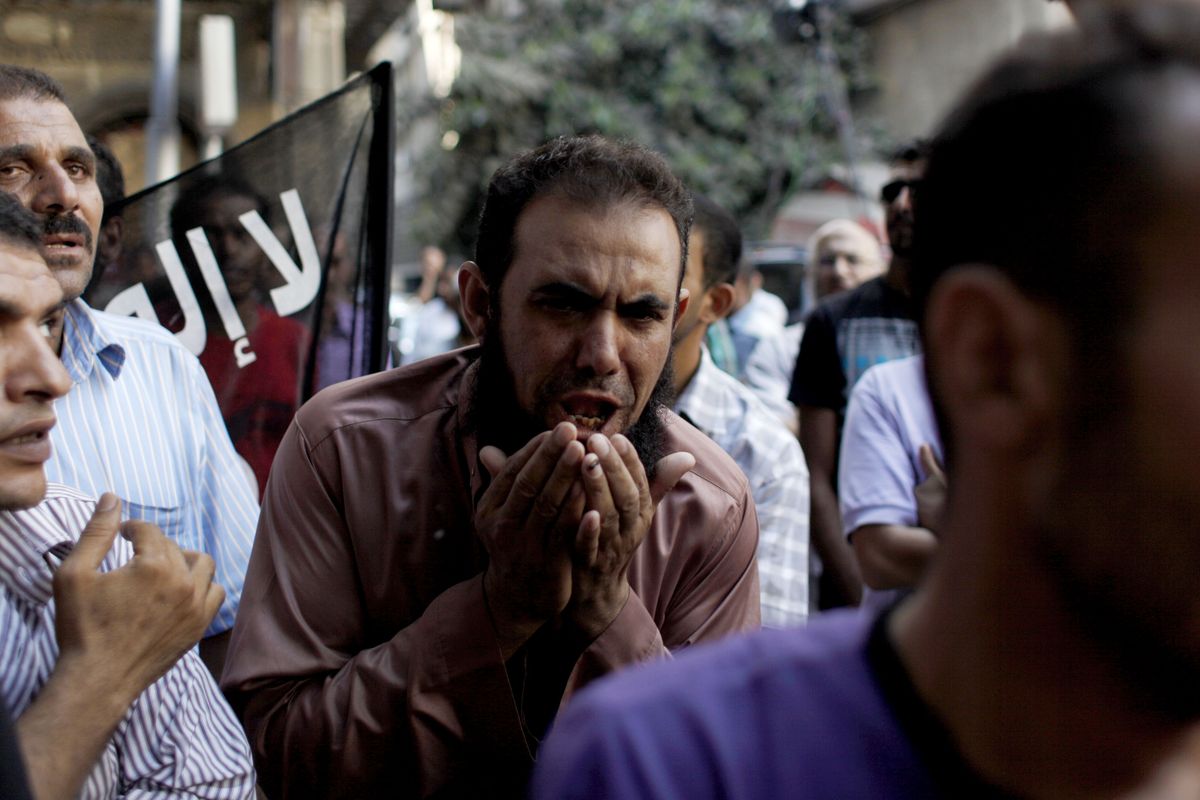 CORRECTS NATIONALITY OF FILMMAKER - An Egyptian man chants slogans during a demonstration in front of the U.S. embassy in Cairo, Egypt, Wednesday, Sept. 12, 2012, as part of widespread anger across the Muslim world about a film ridiculing Islam