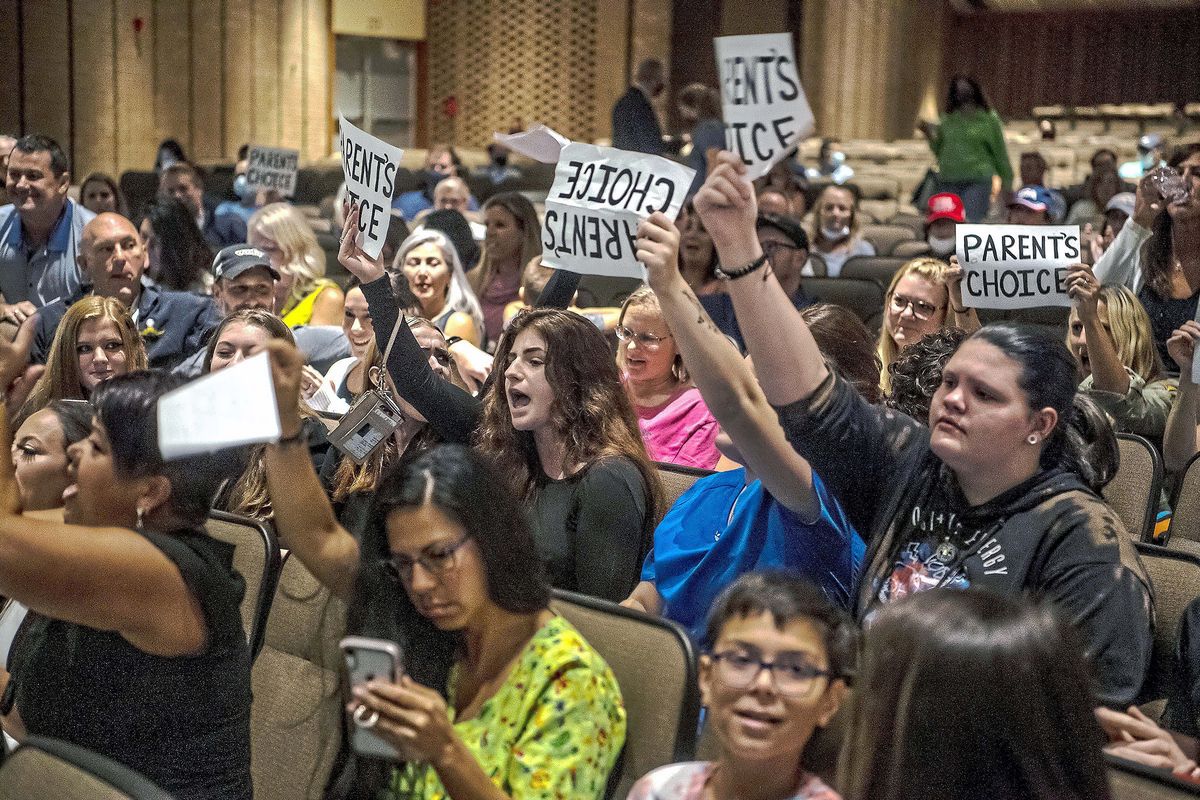 People hold signs and chant during a meeting of the North Allegheny School District board regarding the district’s mask policy, Aug. 25 in McCandless, Pa.  (Alexandra Wimley)