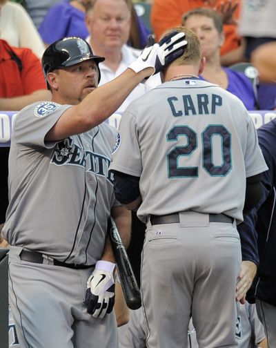 Seattle Mariners' Kevin Millwood congratulates Mike Carp (20) after Carp hit a solo home run off Colorado Rockies starting pitcher Alex White during the second inning of an interleague baseball game, Friday, May 18, 2012, in Denver. (Jack Dempsey / Fr42408 Ap)