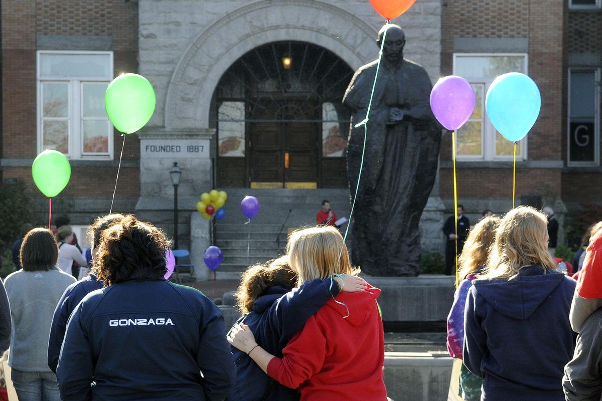 Gonzaga students share an embrace during a witness for justice gathering near the reflecting pool of St. Ignatius outside of College Hall October 21, 2010.  Hundreds of students, staff and faculty assembled while the Westboro Baptist Church members picketed across campus. (Dan Pelle / The Spokesman-Review)