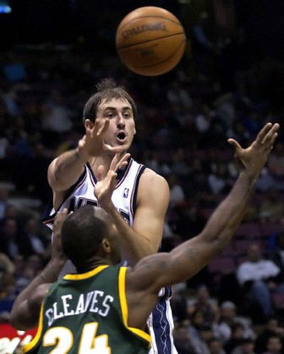 
New Jersey's Nenad Krstic, left, passes the ball over Seattle's Mateen Cleaves. 
 (Associated Press / The Spokesman-Review)