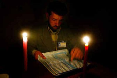 
A counting official for the Independent Electoral Commission of Iraq, starts counting ballot papers under candlelight because of a power cut, in a polling station in the center of Az Zubayr, Iraq, on Sunday. 
 (Associated Press / The Spokesman-Review)