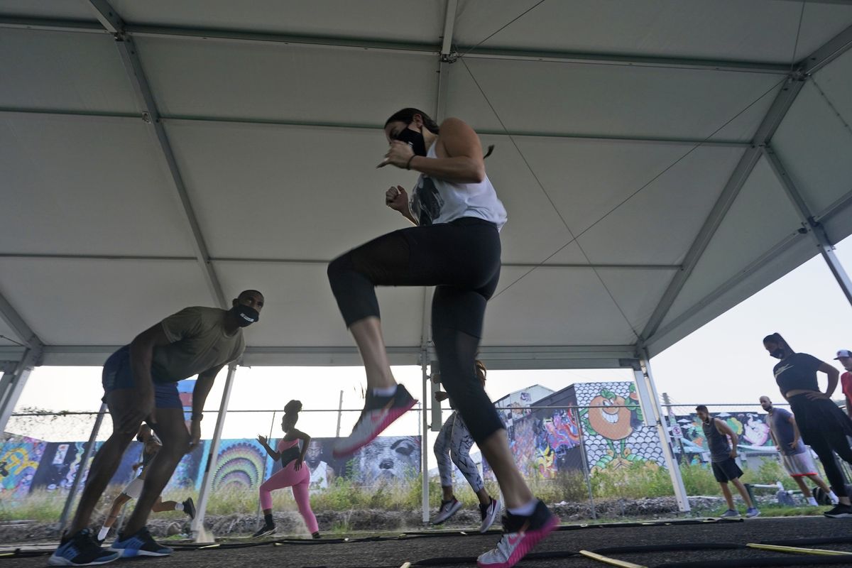 Trainer Xavier Aller motivates a group working out Aug. 31 at Legacy Fit in the Wynwood Art District of Miami.  (Wilfredo Lee/Associated Press)