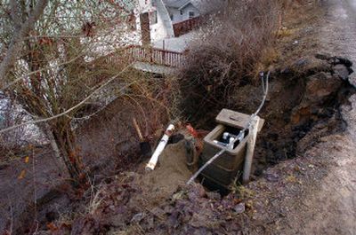 
A flow  of runoff mud  from the hillside above East Upper Hayden Lake Road on Tuesday scoured the soils from around this sewer and water connection, breaking a sewer line. 
 (Jesse Tinsley / The Spokesman-Review)