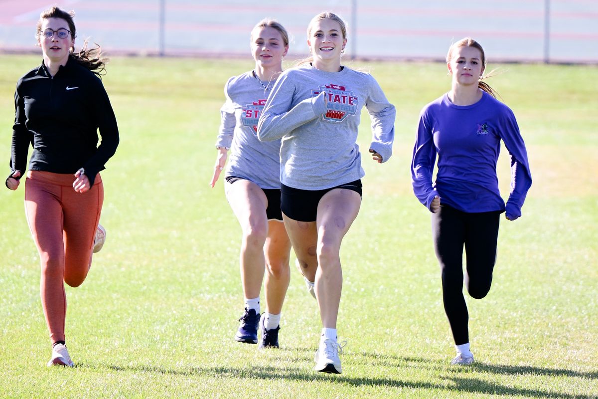 University High School cross country runner Kyla Roberts, second from right, runs in stride with her teammates on Tuesday at University High School in Spokane Valley.  (Tyler Tjomsland/The Spokesman-Review)