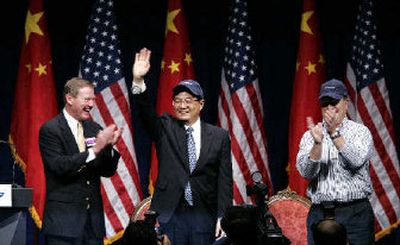 
Chinese President Hu Jintao waves after being given a Boeing hat by company employee Paul Dernier, right, as Boeing CEO Alan Mulally watches after Hu addressed Boeing Co. employees in Everett.  
 (Associated Press / The Spokesman-Review)