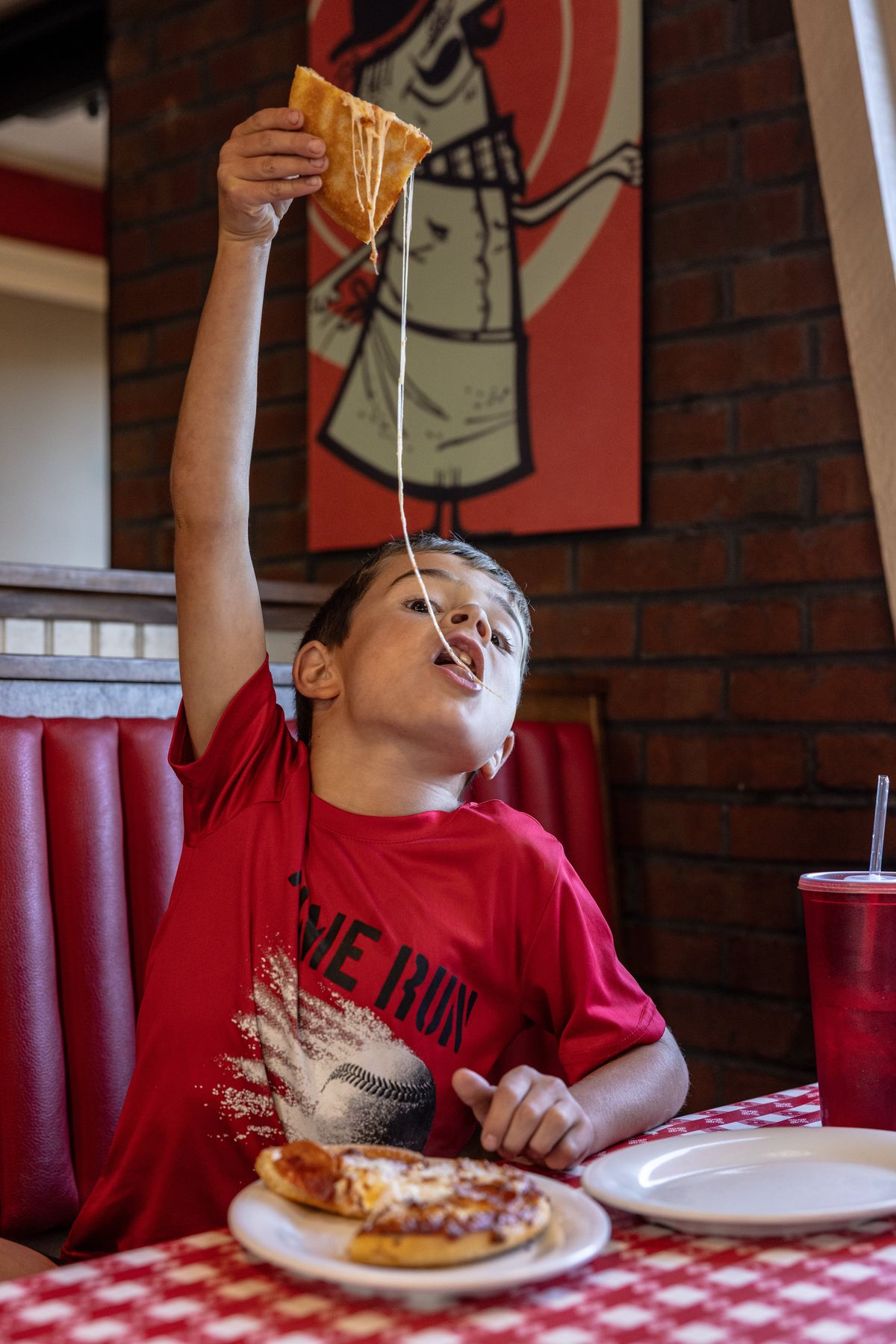 Brooks Burton lifts a piece of his personal pan pizza at a Pizza Hut in Louisa, Virginia.  (Parker Michels-Boyce/For The Washington Post)