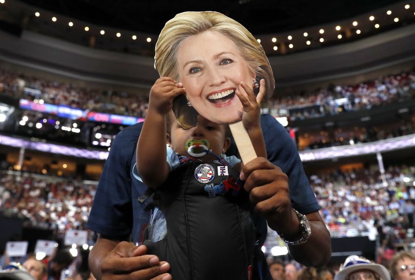 16-month Ethan Jennings grabs a cardboard cutout of the face of Democratic Presidential candidate Hillary Clinton as his father Florida delegate Bernard Jennings holds him during the second day session of the Democratic National Convention in Philadelphia, Tuesday, July 26, 2016. (AP Photo/Carolyn Kaster)