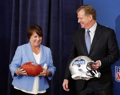 Tennessee Titans owner Amy Adams Strunk holds a football as she and NFL commissioner Roger Goodall prepare for a photo after it was announced that Nashville will host the 2019 NFL draft during the NFL owner's spring meeting Wednesday, May 23, 2018, in Atlanta. (John Bazemore / Associated Press)