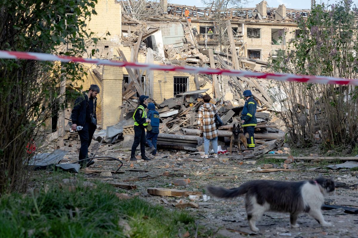 Police officers and local residents stand next to damaged apartment buildings following a Russian missile attack Thursday in Kyiv, Ukraine. (Tetiana Dzhafarova/AFP)