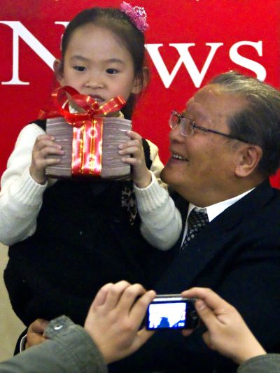 A girl holds the first Confucius Peace Prize, given in Beijing  Thursday.  (Associated Press)