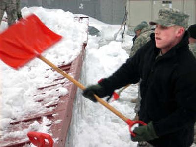 
Pvt. Chris Kearbey shovels snow off the roof of Sandpoint High School on Saturday. 
 (Shawn Vestal / The Spokesman-Review)