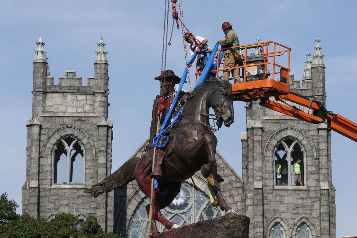 In this July 7, 2020 photo, crews attach straps to the statue Confederate General J.E.B. Stuart on Monument Avenue in Richmond, Va. At least 160 Confederate symbols were taken down or moved from public spaces in 2020. That