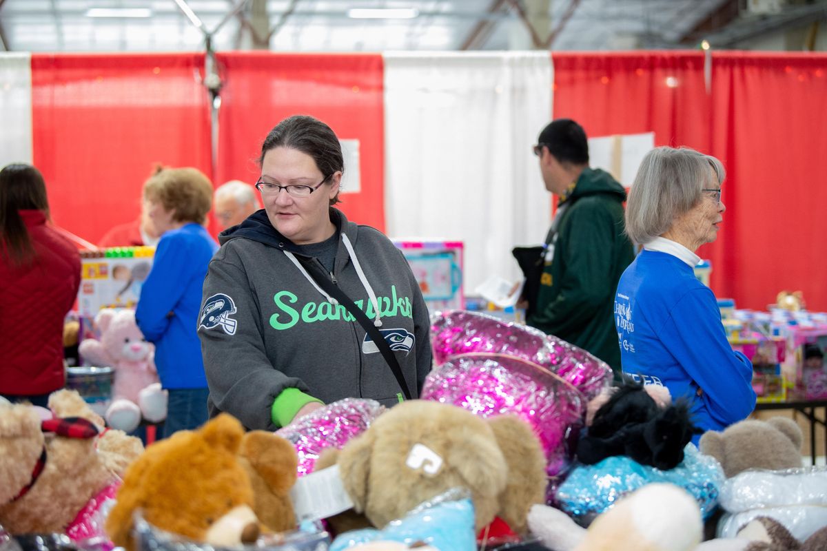 Candice Hieb searches the Christmas Bureau Toy Room diligently Friday, Dec. 21, 2018 for a gift for her teenage daughter. It was the last day of the Bureau, which opened Dec. 12. (Jesse Tinsley / The Spokesman-Review)