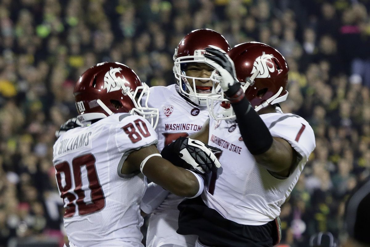 Washington State receiver Dom Williams, left, celebrates his touchdown reception with teammates Vince Mayle, right, and Isiah Myers in the first quarter. Williams had 59 yards receiving. (Associated Press)