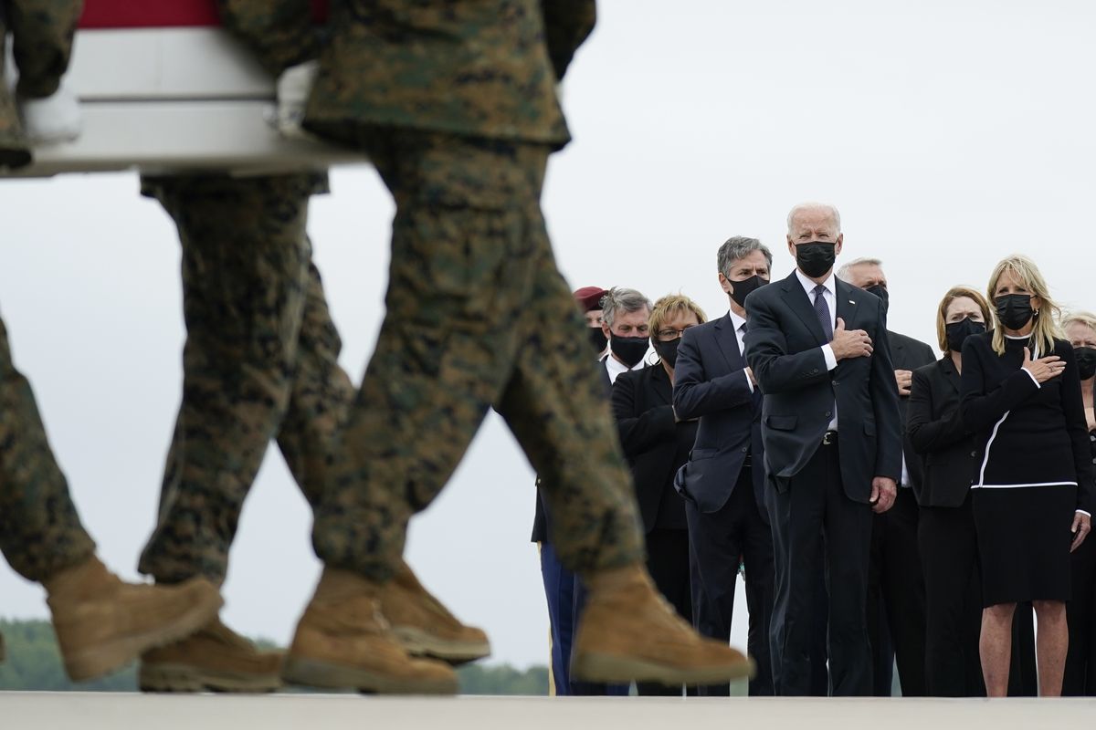 President Joe Biden and first lady Jill Biden watch as a carry team moves a transfer case containing the remains of Marine Corps Lance Cpl. Kareem M. Nikoui, 20, of Norco, Calif., during a casualty return Sunday, Aug. 29, 2021, at Dover Air Force Base, Del. According to the Department of Defense, Nikoui died in an attack at Afghanistan