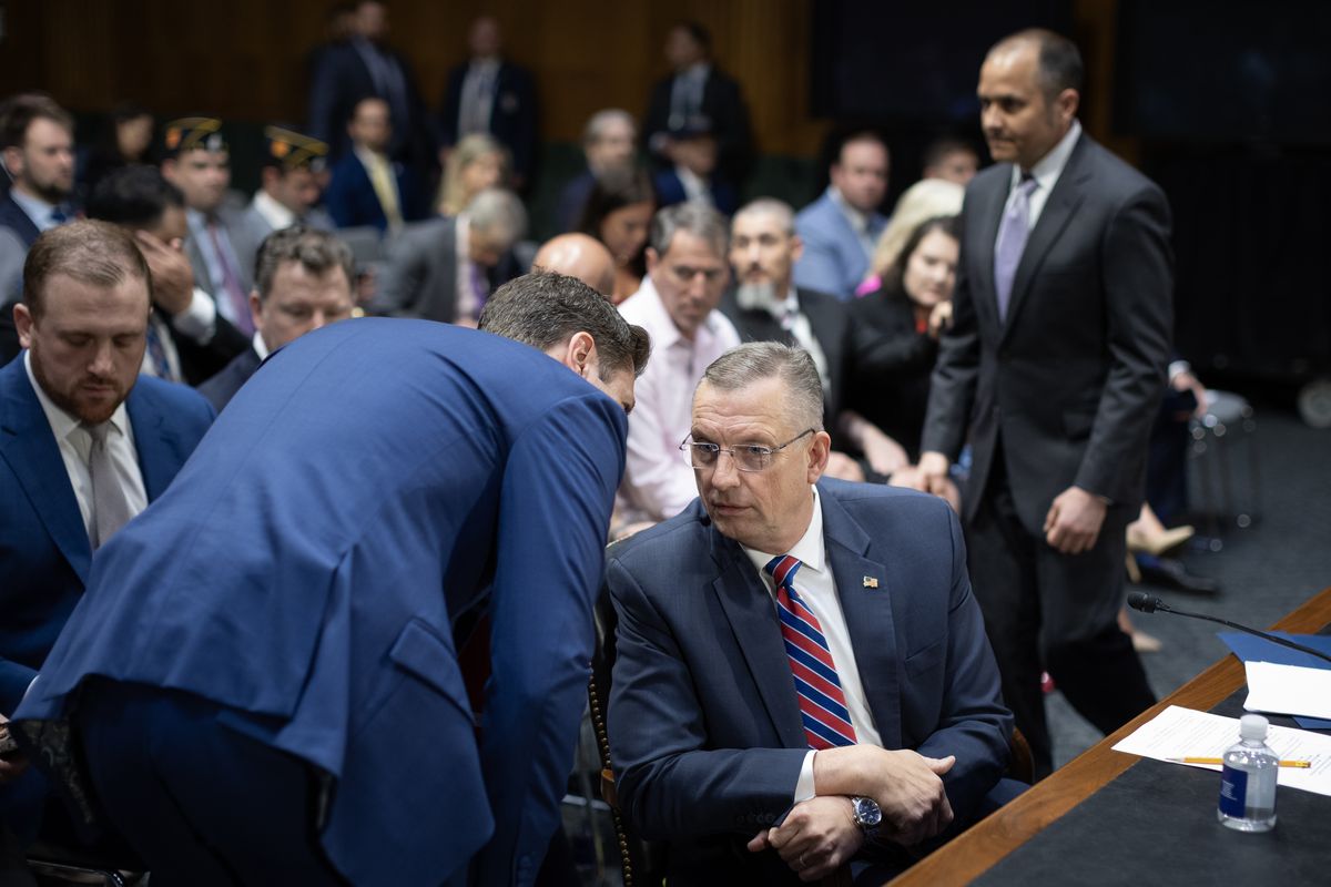 A staff member speaks to Veterans Affairs Secretary Douglas A. Collins before Collins testifies May 6 at a Senate hearing.  (Tom Brenner/For The Washington Post)