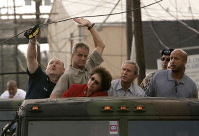 
Vice Adm. Thad Allen, left, and an unidentified man help lift a downed power line during a tour of downtown New Orleans with President Bush on Monday. 
 (Associated Press / The Spokesman-Review)
