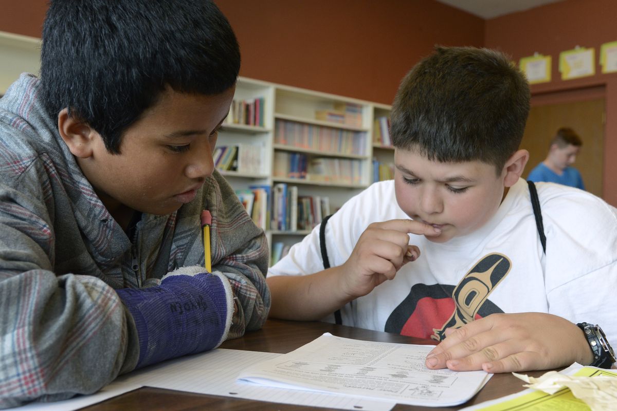 During after-school tutoring at the Boys & Girls Club, Lidgerwood Elementary School sixth-graders Edward Anos, 11, left, and Blake Dashiell, 12, work together on a spelling assignment. The boys are part of the Reach for the Future program that will provide a group of Lidgerwood students money for college. (Colin Mulvany)