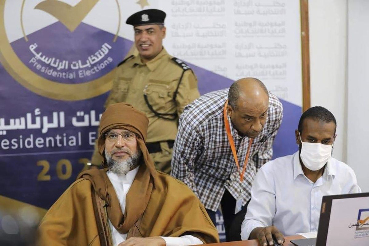 Seif al-Islam, left, the son and one-time heir apparent of late Libyan dictator Moammar Gadhafi registers his candidacy for the country’s presidential elections next month, in Sabha, Libya, Sunday, Nov. 14, 2021. Al-Islam, who was seen as the reformist face of Gadhafi