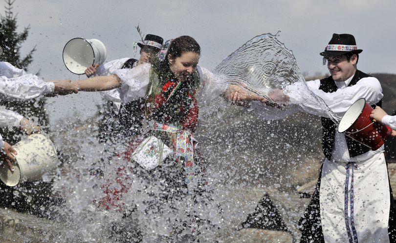 Boys of the Paloc minority, dressed in their traditional clothing, pour buckets of water on a girl in the village of Holloko, 100 kilometers (62 miles) north-east of Budapest, Hungary, Friday, March 26, 2010, during a practice performance of this typical Hungarian Easter tradition. (Bela Szandelszky / Associated Press)