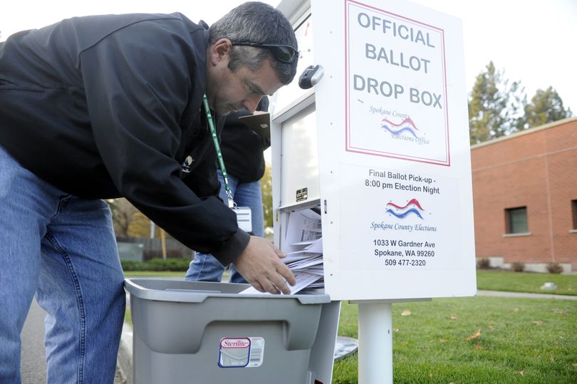 Elections worker Mike McLaughlin removes ballots from the drop box outside the South Hill Library on Monday. For a list of drop boxes in Spokane County and resources for other counties, see Page A12. (The Spokesman-Review)