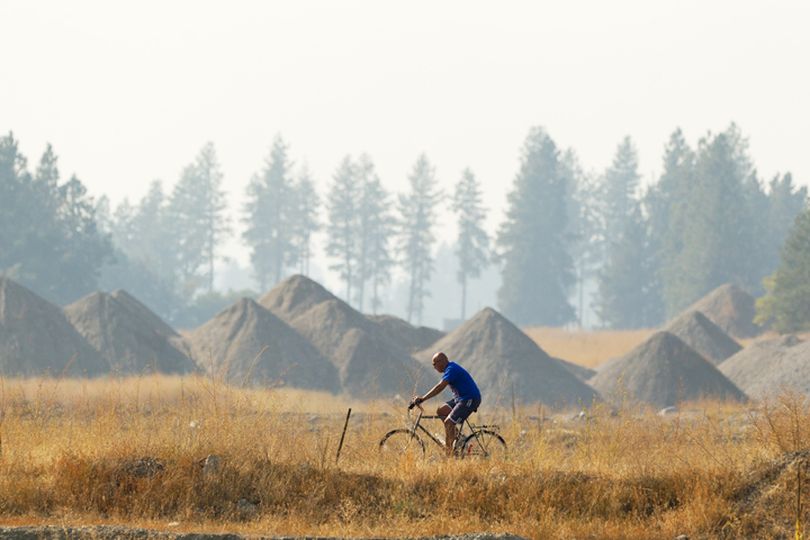 SHAWN GUST/Press

Carlos Venzor, of Coeur d'Alene, rides on the Centennial Trail Thursday as hazy skies diffuse the landscape around him. (Shawn Gust)