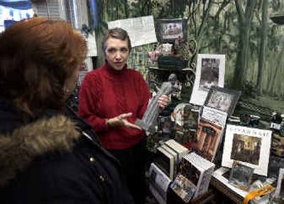 
 Trese Newman shows Pat Cadaret, left, of Schenectady, N.Y., a small-scale version of the Bird Girl statue for sale in The Book Gift Shop in Savannah, Ga., in January. 
 (Associated Press / The Spokesman-Review)