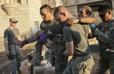 U.S. Army soldiers carry an Iraqi  soldier after treating him for a gunshot wound in Mosul,  northwest of Baghdad,  on Thursday.  (Associated Press / The Spokesman-Review)