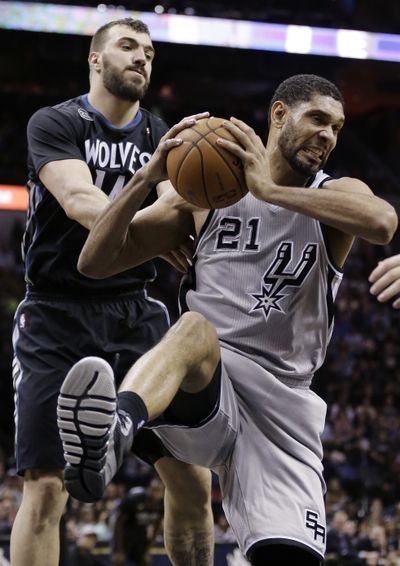 San Antonio’s Tim Duncan grabs a rebound away from Minnesota’s Nikola Pekovic. The Spurs collected a 104-86 victory at home. (Associated Press)