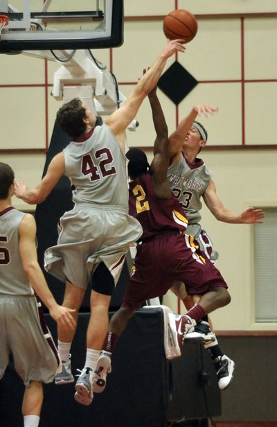 Whitworth’s Jack Loofburrow (42) and Clay Gebbers reject Willamette’s Terrell Malley in the first half. (Dan Pelle)