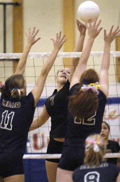 
University's Kristina Kielbon tips the ball past Megan Thigpen (11) and Nicole Solum (12) of Mead in the first game of U-Hi's sweep. 
 (Colin Mulvany / The Spokesman-Review)