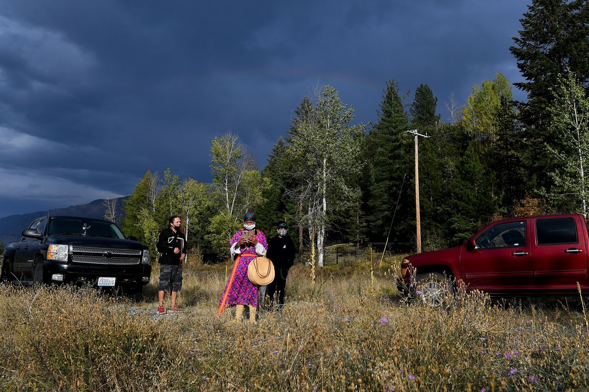 Virginia Redstar, center, with the River Warrior Society checks her phone as storm clouds roll in following a gathering of Colville Confederated Tribe members and supporters at the Boundary-Waneta Border Crossing in support of Rick Desautel's case in the Canadian Supreme court arguing for the Sinixt peoples' right to hunt traditional lands in Canada on Thursday, October 8, 2020, near Northport, Wash. Desautel, a member of Lakes Tribe of the Colville Confederated Tribes, shot a cow elk in British Columbia in 2010 to assert the Sinixt people's rights to hunt the traditional lands and to challenge a Canadian declaration 60-years-ago that the Sinixt people were extinct.  (Tyler Tjomsland/THE SPOKESMAN-REVIEW)