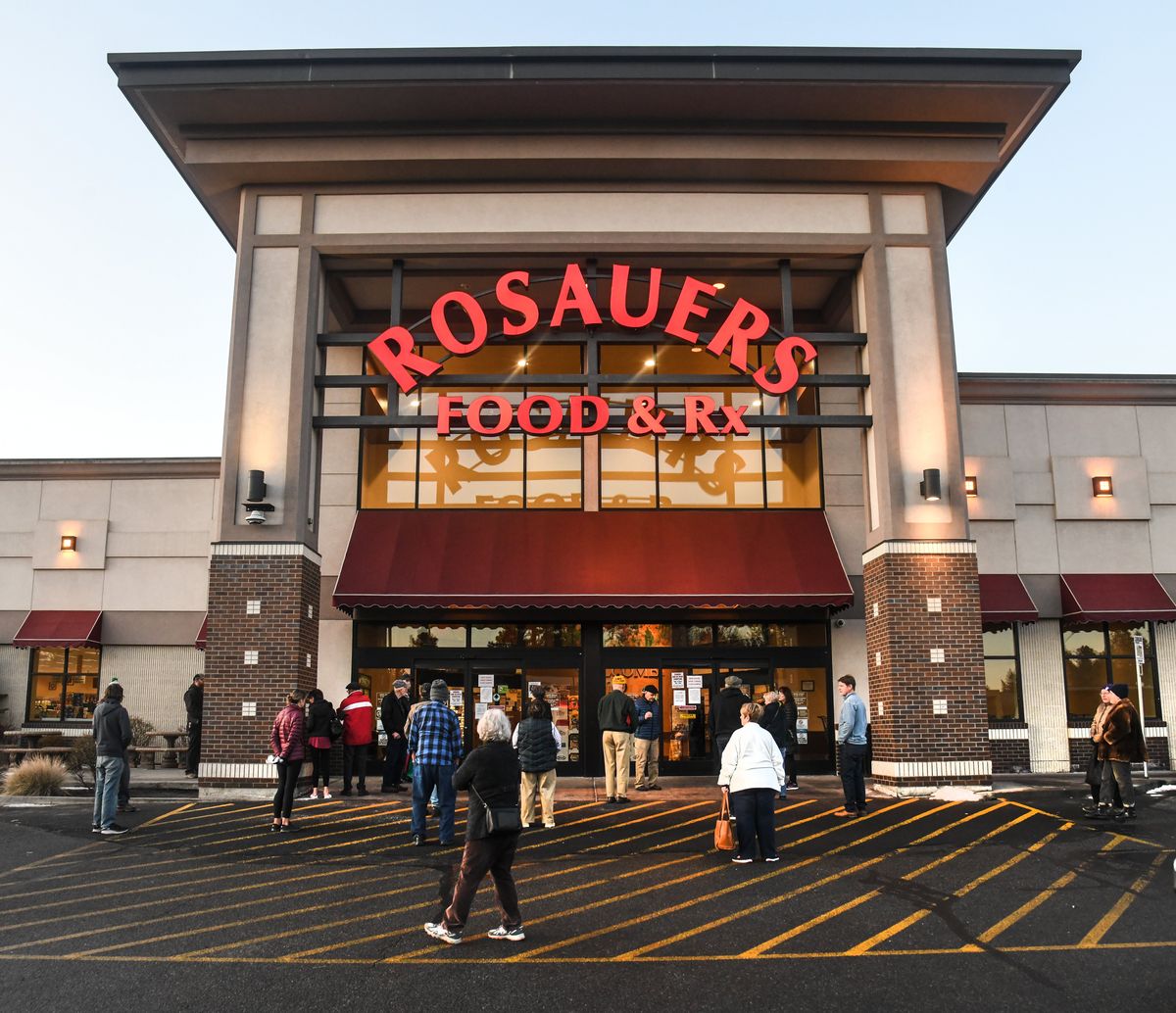 Rosauers customers line up March 19, 2020, before shopping at the grocery store on 29th Avenue in Spokane. Rosauers COO Mike Shirts is retiring after 50 years with the company. (DAN PELLE/The Spokesman-Review)