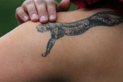 
Before she throws, Marissa Tschida gets a little encoura- gement from Chester, her cheetah.
 (The Spokesman-Review)