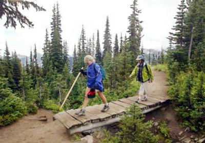 
Kris Grose, left, and Gretchen Ariz hike the Wonderland Trail in Mount Rainier National Park in 2003. The park's budget falls  short about  $275,000 a year. 
 (File Associated Press / The Spokesman-Review)