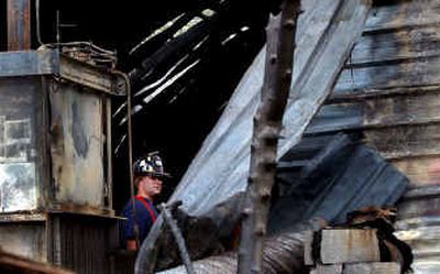 
Bill Clifford, driver operator for Northern Lakes Fire District, searched for a clue to the fire at Brix Pallet Co. in Rathdrum on Thursday morning. 
 (Kathy Plonka / The Spokesman-Review)