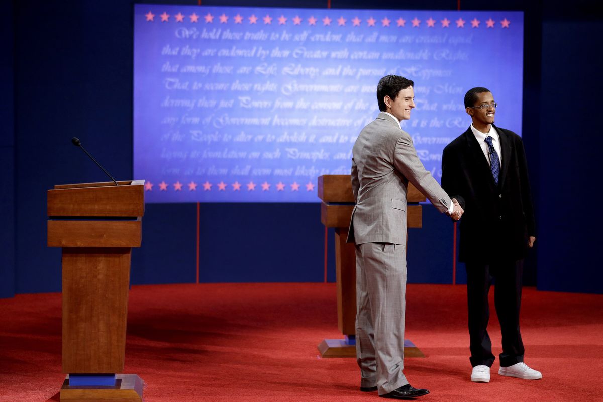Stand-ins for Republican presidential candidate, former Massachusetts Gov. Mitt Romney, left, and President Barack Obama shake hands on stage during a rehearsal. (Associated Press)