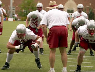 Dan Rowlands, left, and Kenny Alfred work on a drill as offensive line coach George Yarno, back to camera, yells instructions. Associated Press
 (Associated Press / The Spokesman-Review)