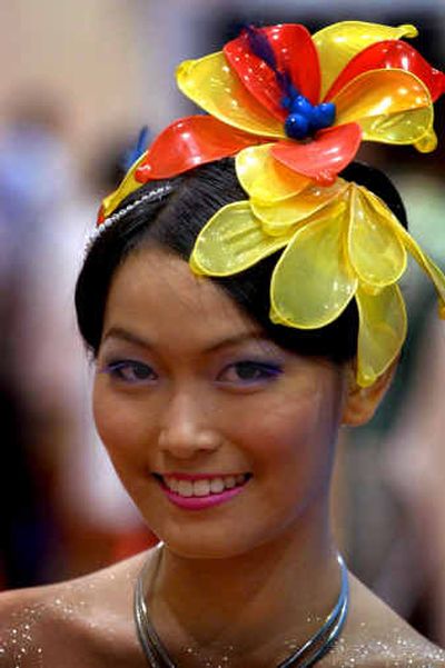 A model wears a collection of condoms simulating an orchid in her hair as she works in the commercial area Tuesday during the 15th AIDS Conference in Bangkok, Thailand.
(Associated Press / The Spokesman-Review)