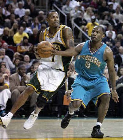 
Seattle's Rashard Lewis, left, drives against the Hornets' George Lynch. 
 (Associated Press / The Spokesman-Review)