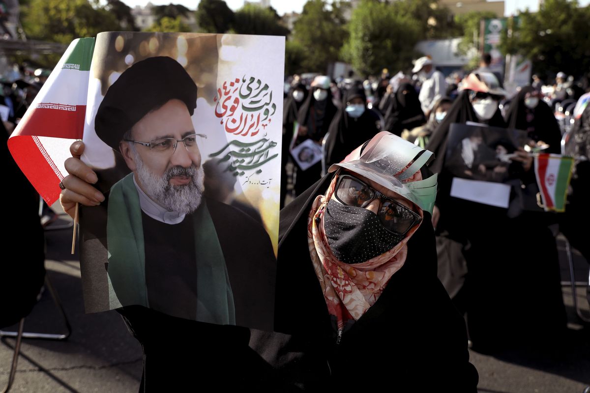 A supporter of presidential candidate Ebrahim Raisi holds a sign during a rally in Tehran, Iran, Wednesday, June 16, 2021. Iran